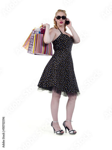 young female carrying shopping bags and talking on cellphone.