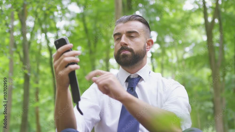 Hipster businessman trying to get signal to make a phone call in the woods Hipster businessman trying to get signal to make a phone call in the woods