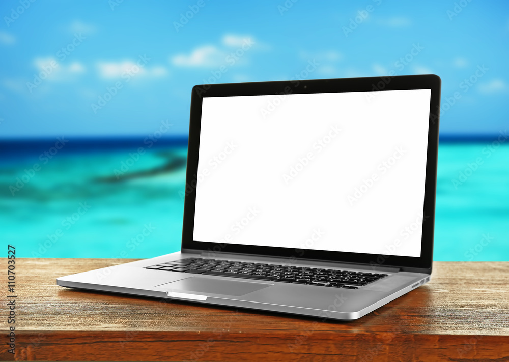 Laptop over wooden table on nature background Laptop over wooden table on nature background