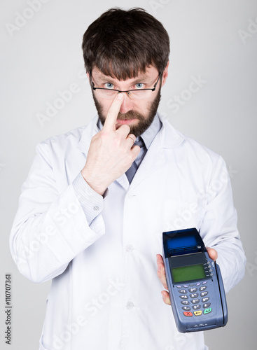 close-up portrait of a medical doctor, he proposes to pay for treatment in pos-terminal. concept of high cost of the treatment 