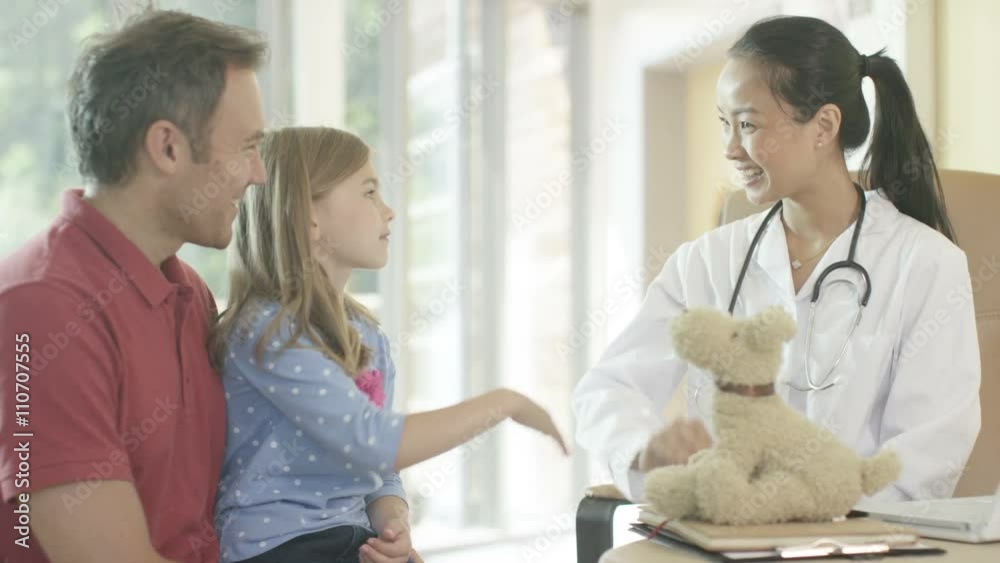 Friendly doctor talking to parent and child patient in office Friendly doctor talking to parent and child patient in office