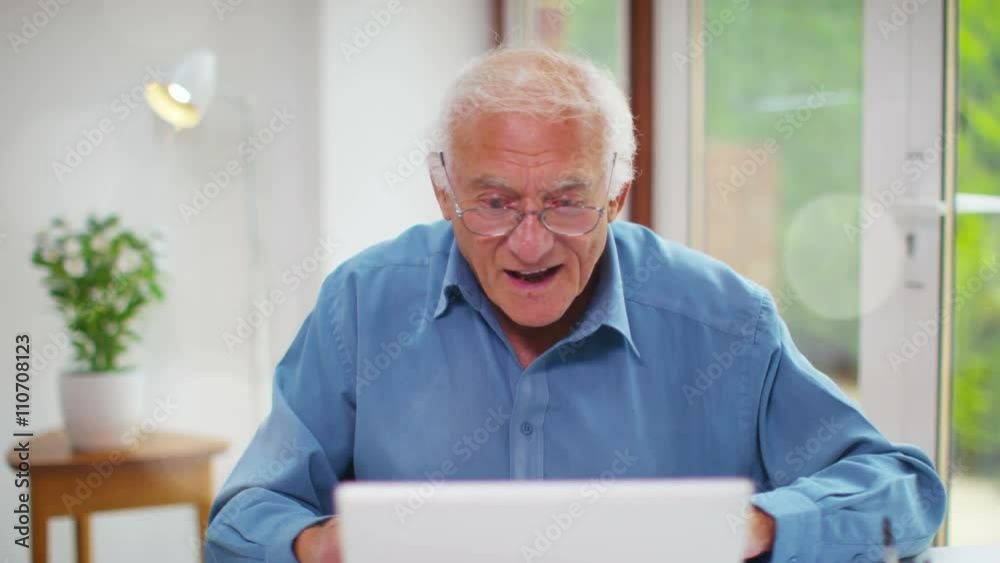 Cheerful senior man engaged in video call on laptop computer. Shot on RED Epic. Cheerful senior man engaged in video call on laptop computer. Shot on RED Epic.