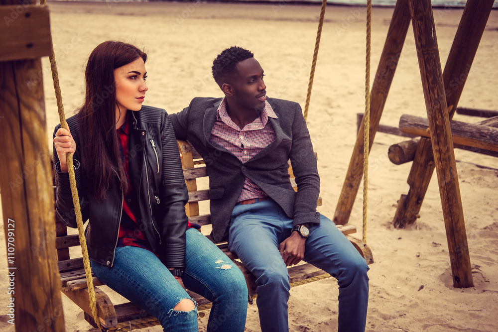Obraz premium Afro american guy and caucasian female on a beach.
