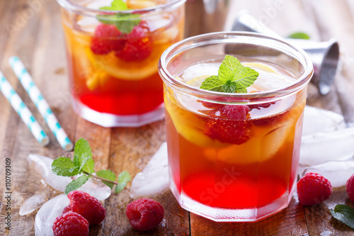 Red summer cocktail with lemons and raspberry
