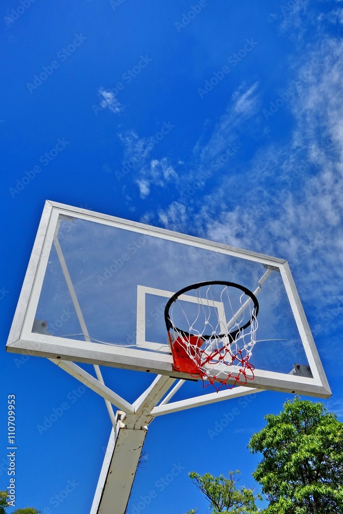 Basketball hoop with sky and sun