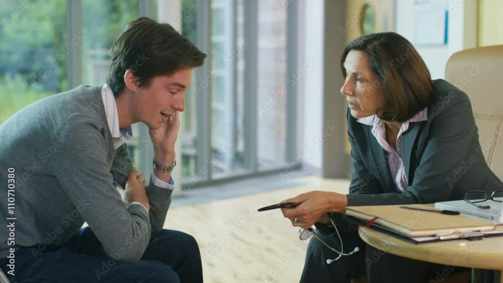 Friendly doctor talking to upset or depressed patient in office Friendly doctor talking to upset or depressed patient in office