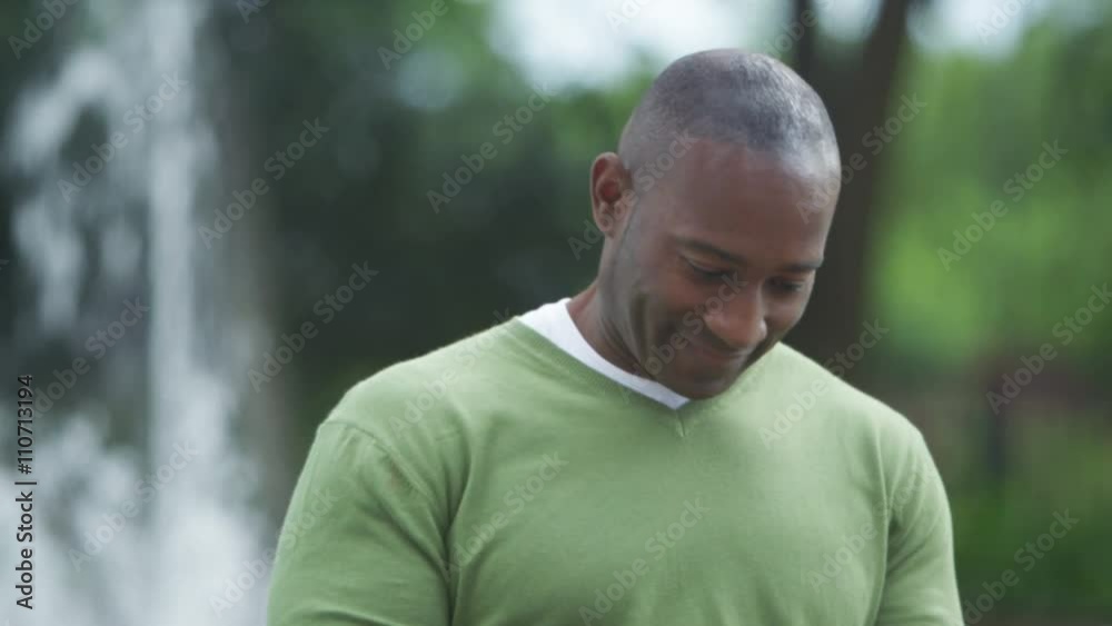  Portrait of attractive smiling man looking at mobile phone outdoors
