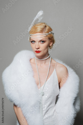 woman in white dress with shoulder straps and long fur stole