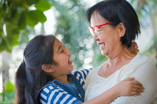 Photography Happy little Asian girl hugging her grandmother