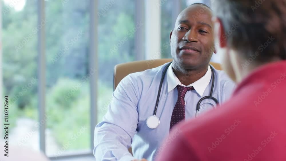  Friendly doctor talking to a couple in his office.