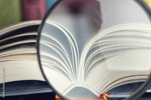 composition with open book and magnifying glass. Back to school, copy space. Education background.