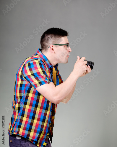 Man with photo camera isolated on gray background