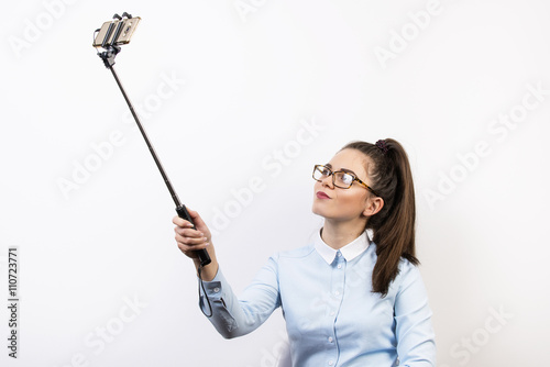 Młoda kobieta robi sobie zdjęcia ze selfiesticka