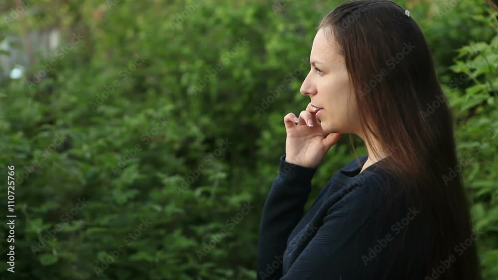beautiful girl talking on the phone in the park among the trees beautiful girl talking on the phone in the park among the trees