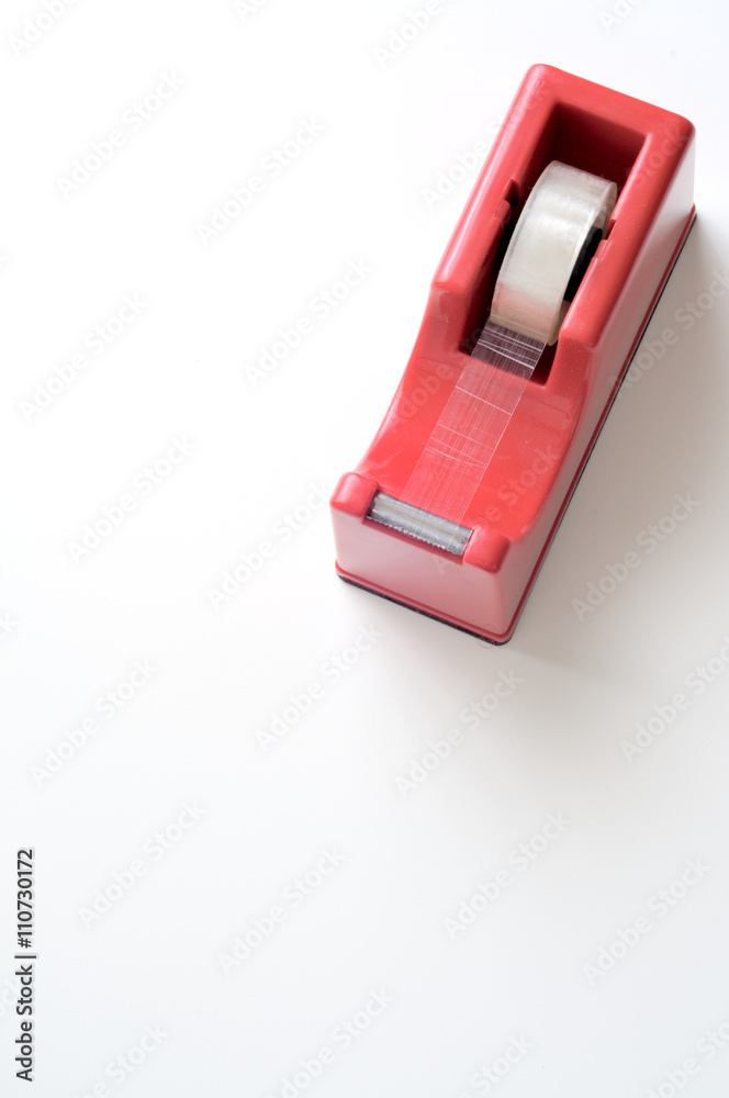 Porta nastro adesivo rosso su scrivania bianca, sfondo verticale Porta nastro adesivo rosso su scrivania bianca, sfondo verticale