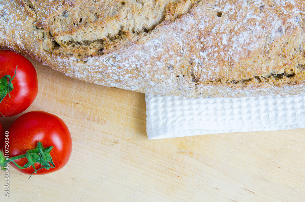 Tomatos and bread on light cutboard Tomatos and bread on light cutboard