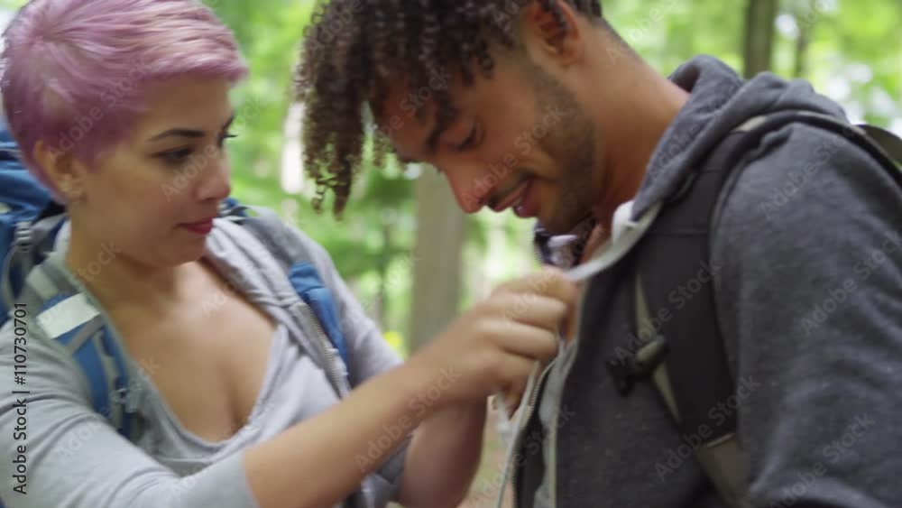Group of friends hiking in the woods putting on backpacks and preparing to walk. Group of friends hiking in the woods putting on backpacks and preparing to walk.