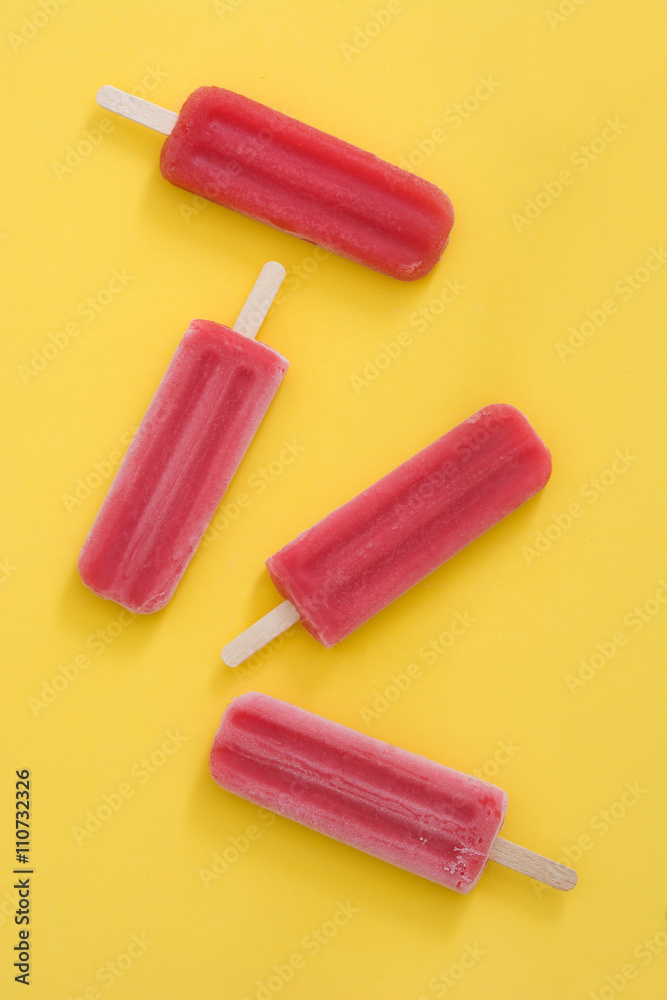 Strawberry popsicle on yellow background
Strawberry popsicle on yellow background