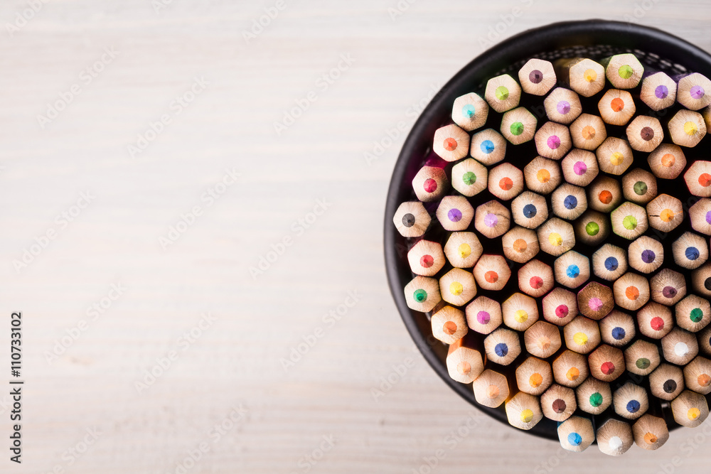 Color pencils in a office bin on wooden background Color pencils in a office bin on wooden background