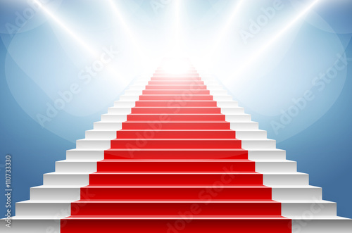 Stairs covered with red carpet. Scene illuminated by a spotlight