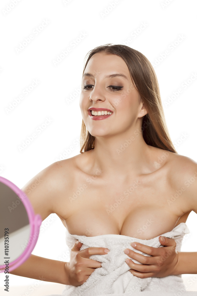 young woman looking and squeezing her breasts and cleavage in the mirror  Stock Photo