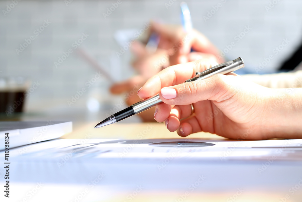 Close-up Of Businesswoman Analyzing Graph with collegues Close-up Of Businesswoman Analyzing Graph with collegues