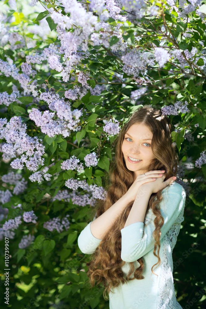 Young beautiful girl in a blossoming spring garden. The blossoming lilac Young beautiful girl in a blossoming spring garden. The blossoming lilac