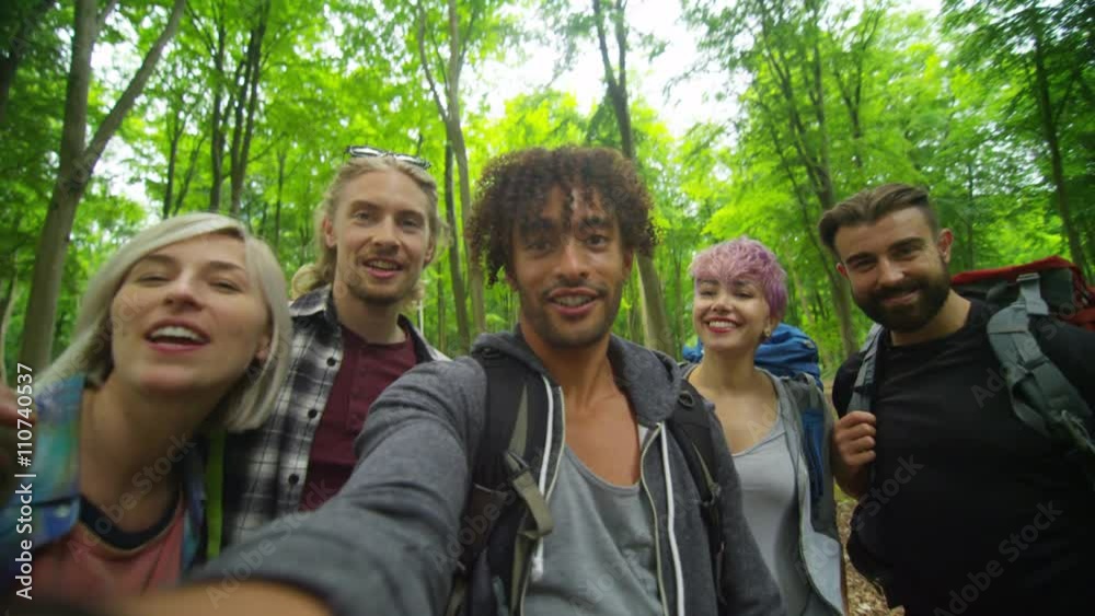 Group of friends hiking in the woods pose to take a selfie. Group of friends hiking in the woods pose to take a selfie.
