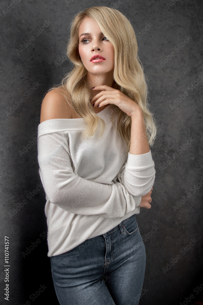 Blonde in white sweater and blue jeans Blonde in white sweater and blue jeans