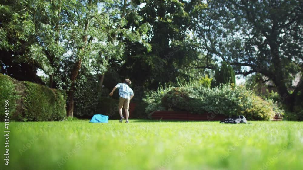 2 Active young boys playing soccer together in the garden 2 Active young boys playing soccer together in the garden