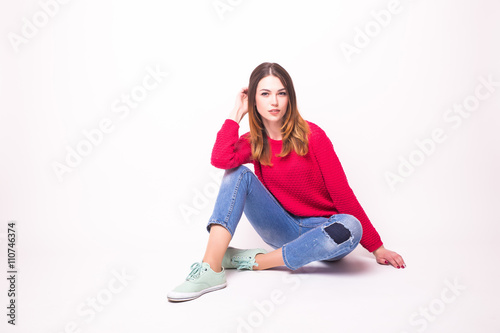 Girl with crossed legs posing on floor on white