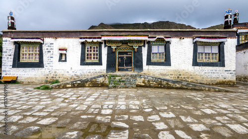 Традиционный тибетский дом с черными окнами и украшенными воротами