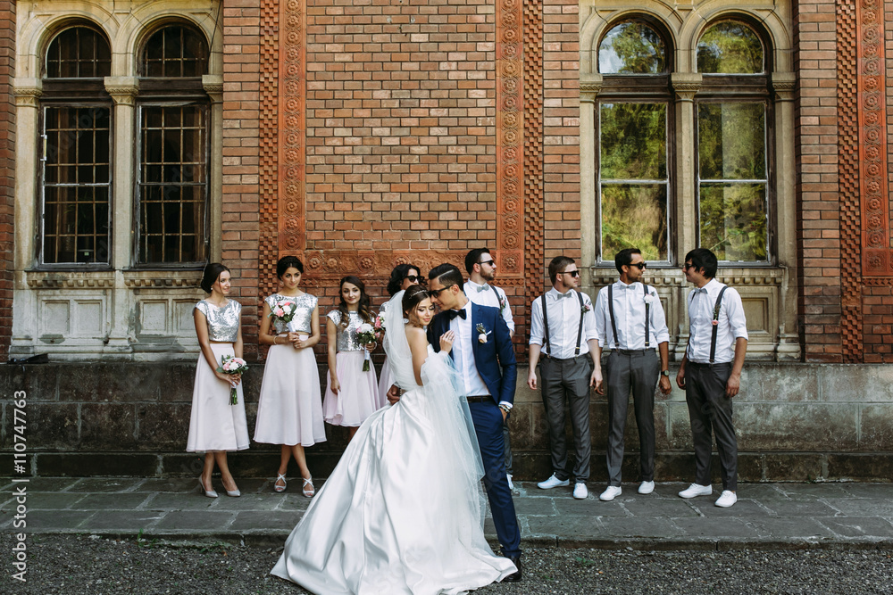 Lovely couple and bridesmaids with groomsmen behind
