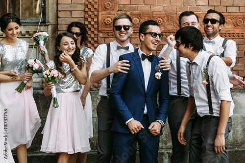Happy groom with bridesmaids and groomsmen