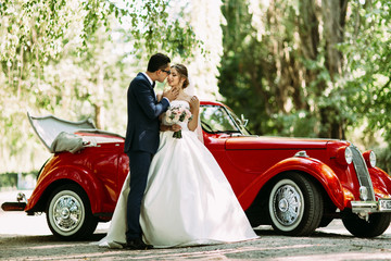 Couple on the wedding and a car on the background