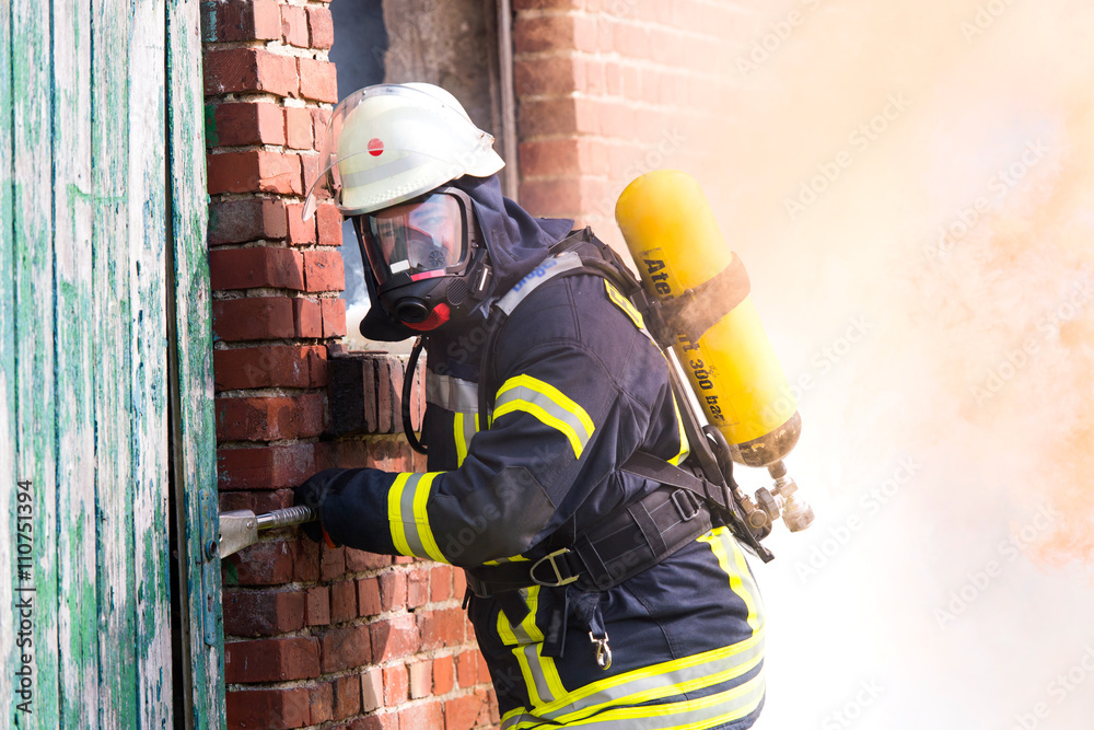 Fototapeta premium Feuerwehrmann im Einsatz am Brandherd