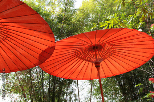 Red paper umbrella made from bamboo stalks.