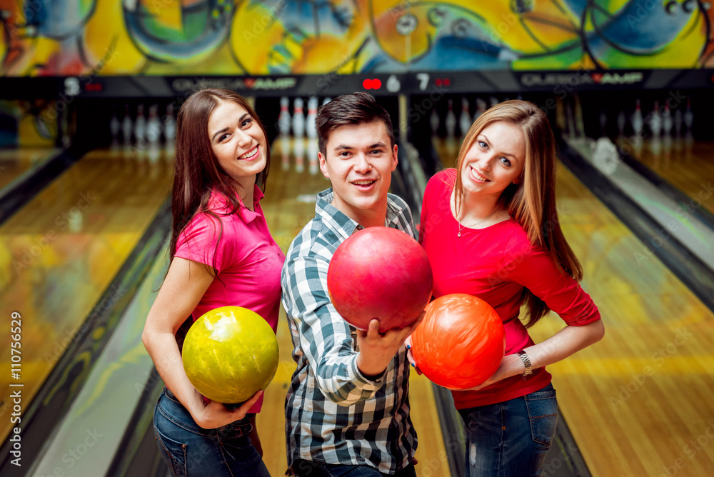 Fototapeta premium Cheerful friends at the bowling alley