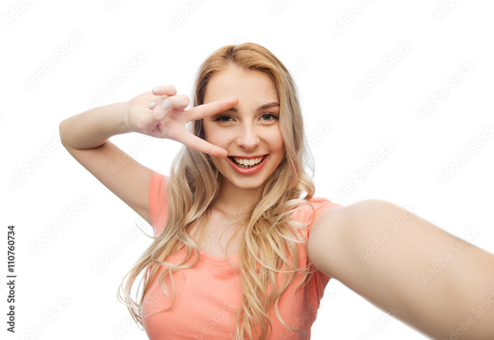 smiling woman taking selfie and showing peace sign smiling woman taking selfie and showing peace sign