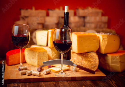 Cheese and wine on a dark table.
