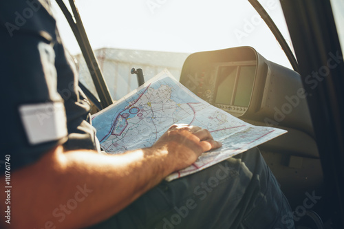 Helicopter pilot studying the flight route map