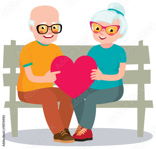 Senior married couple sits on a bench holding a heart symbol