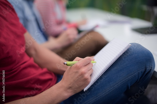male student taking notes in classroom