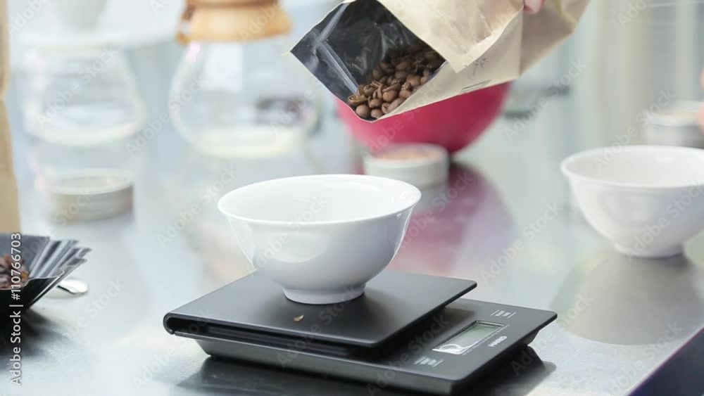 Coffee beans are weighed on kitchen electronic scales. Coffee beans are weighed on kitchen electronic scales.