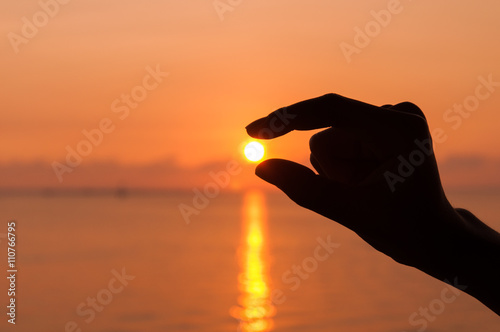silhouette hand picking the sun © korkorkorpai