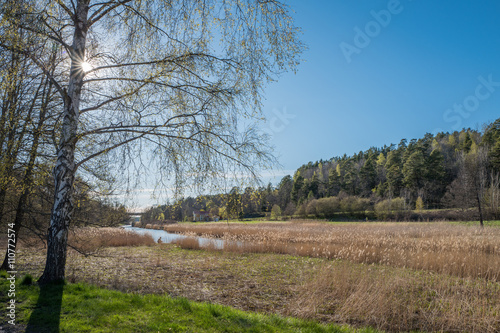 Spring in Sweden - unidentifiable person fishes during spring at Ingarö Canal outside Stockholm, Sweden.
