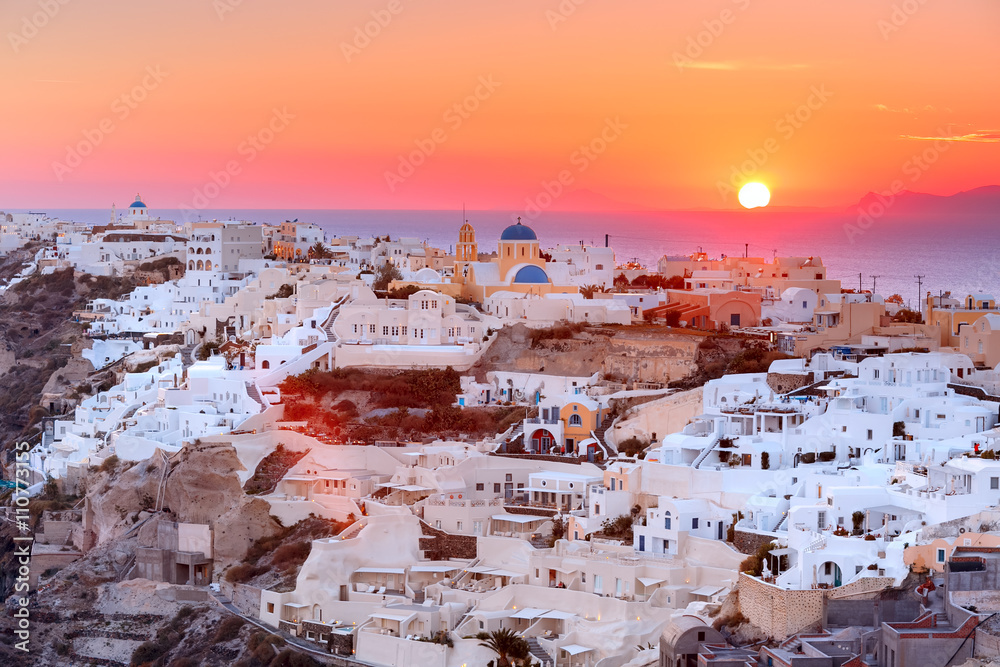 Obraz premium Picturesque view, Old Town of Oia or Ia on the island Santorini, white houses and church with blue domes at sunset, Greece