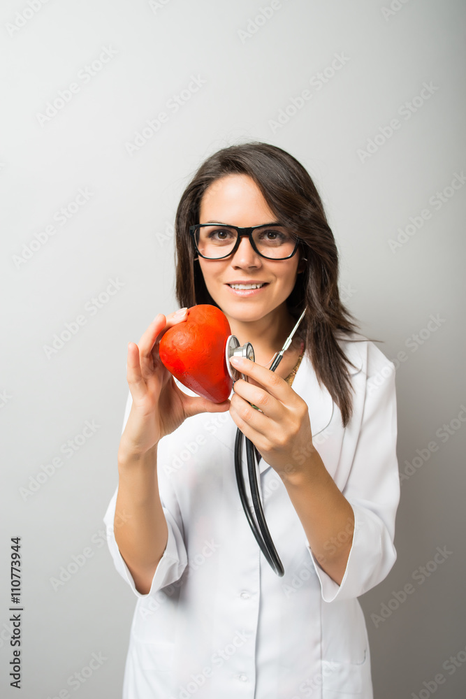 Woman doctor holding a red heart Woman doctor holding a red heart
