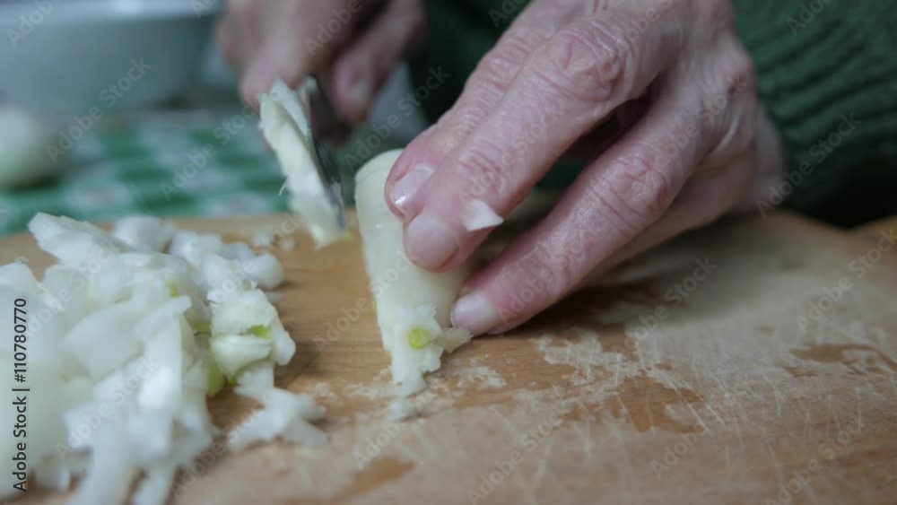 Old wrinkled hands chopping some onions. Old wrinkled hands chopping some onions.