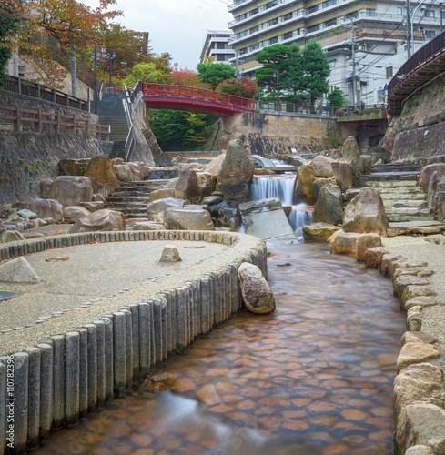 Japanese style public park in autumn with little falls photo
